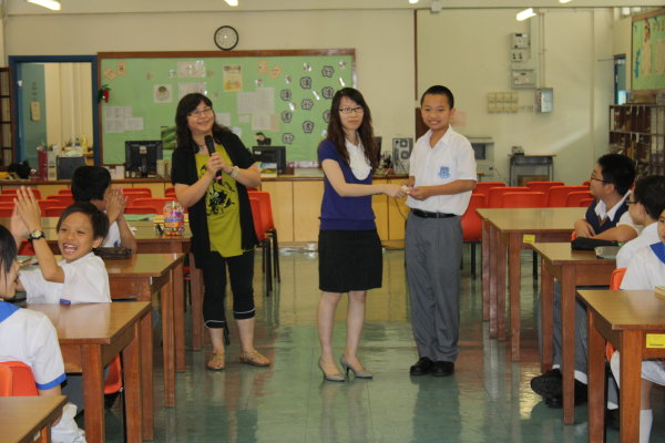  1A同學獲得全班最佳書本報告獎, 圖為班主任梁伊敏老師為同學頒獎。